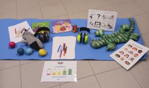 kuvassa erilaisia aistivälineitä ja kuvallisia ohjeita